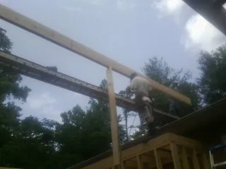 Carpenter setting a ridge beam over a new addition frame — Ice Dam Removal by Roofing Brothers in Bremen