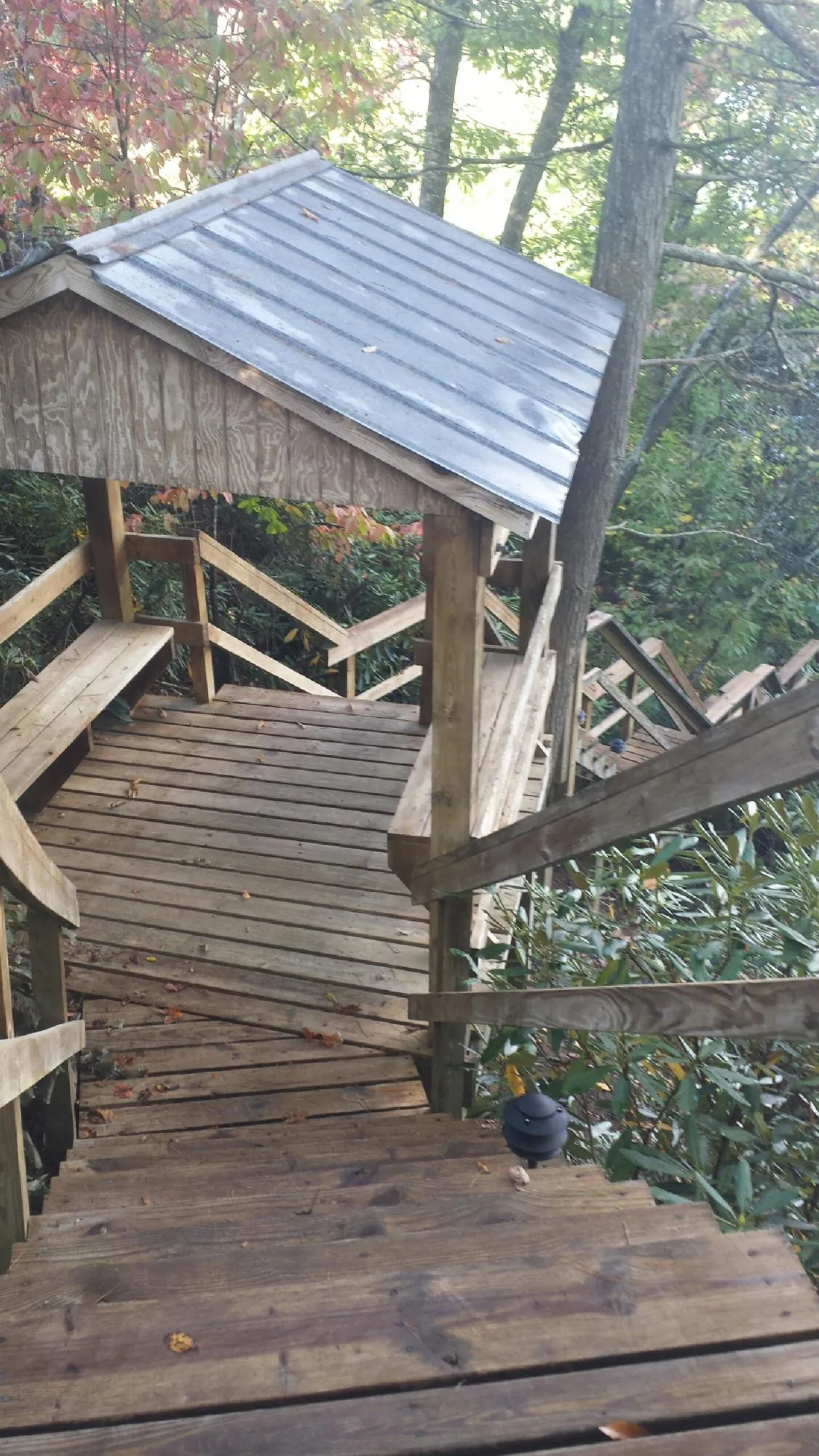 Metal roofed shelter over wooden steps on a wooded walkway — Skylight Repair & Installation work by our crew in Bremen